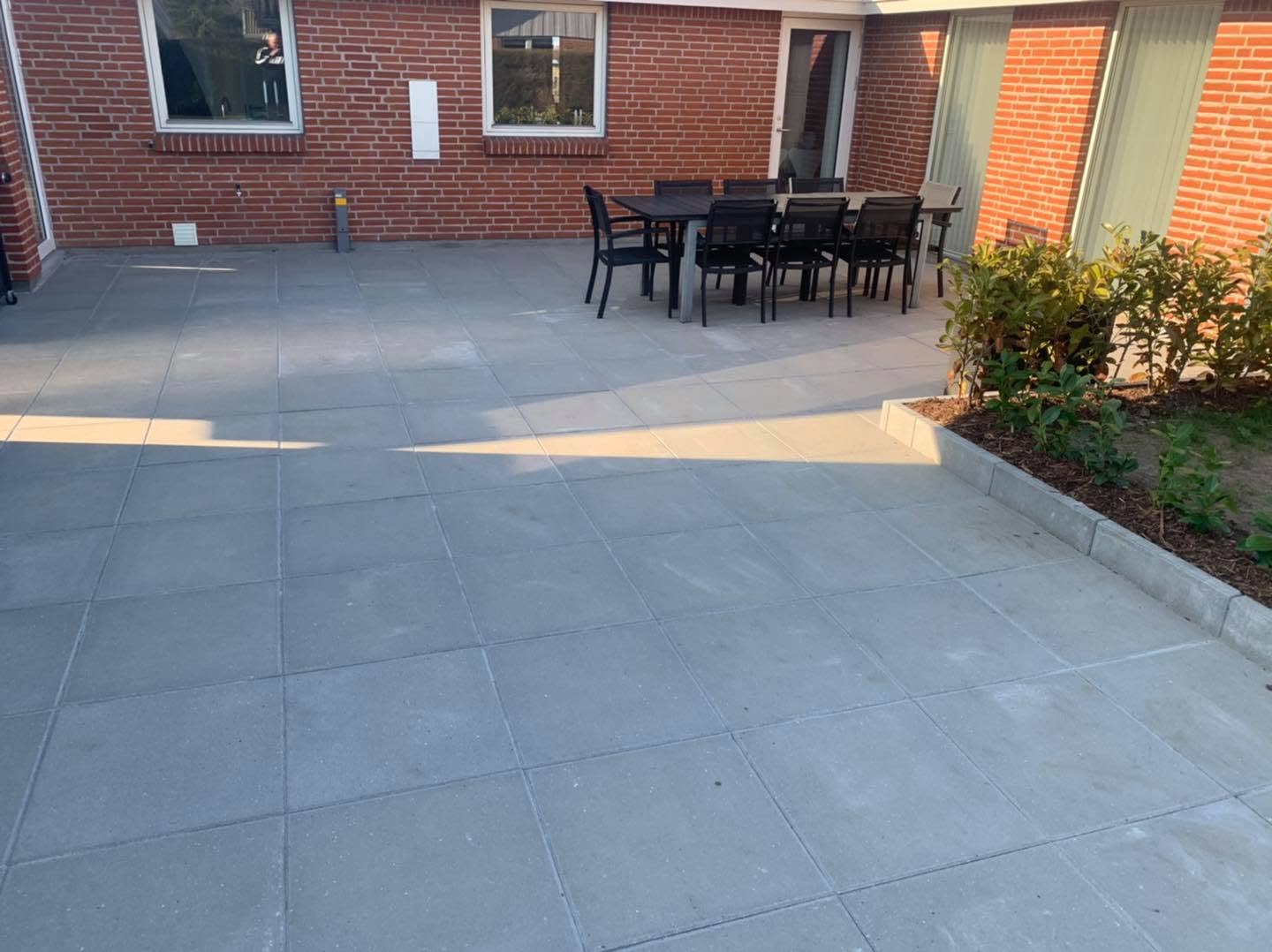 Terrasse med fliser og plantebed